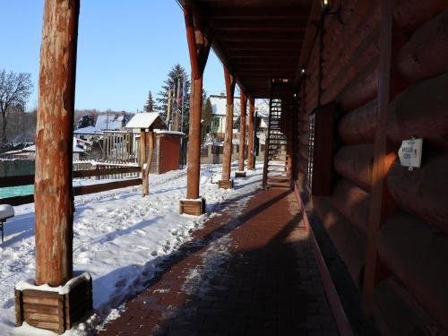 a porch of a building with snow on the ground at Sport-hotel Šibeniční vrch in Mnichovice