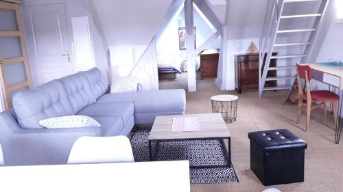 ein Wohnzimmer mit einem Sofa und einem Tisch in der Unterkunft L'ecrin vannetais in Vannes