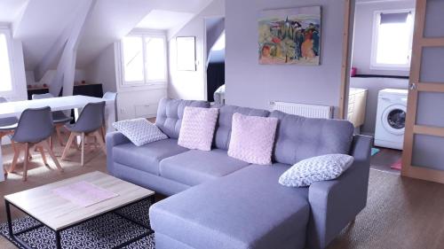 un salon avec un canapé bleu et une table dans l'établissement L'ecrin vannetais, à Vannes