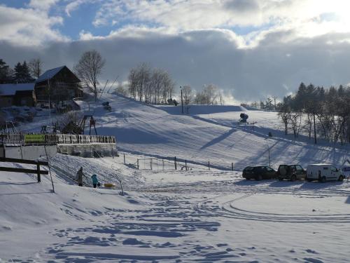a snow covered slope with cars parked on it at Sport-hotel Šibeniční vrch in Mnichovice