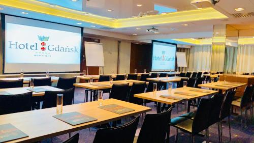 a conference room with tables and chairs and a projection screen at Hotel Gdańsk Boutique in Gdańsk