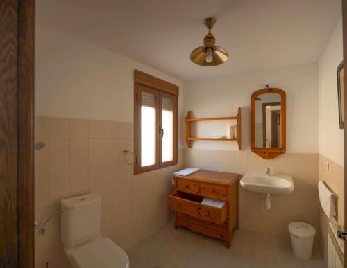 a bathroom with a toilet and a sink and a mirror at Casa Rural Gafas in El Toboso