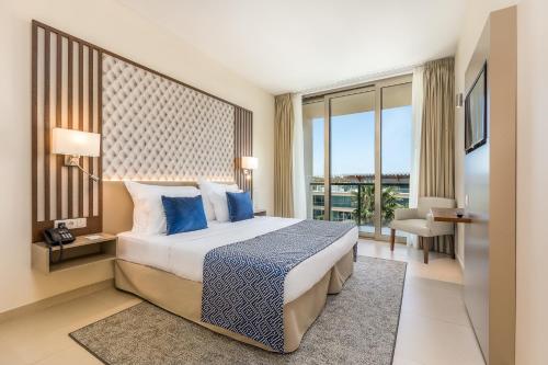 um quarto com uma cama com almofadas azuis em NAU Salgados Dunas Suites em Albufeira