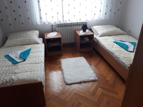 two twin beds in a room with a wooden floor at Kuća za odmor Mažuran in Karlovac