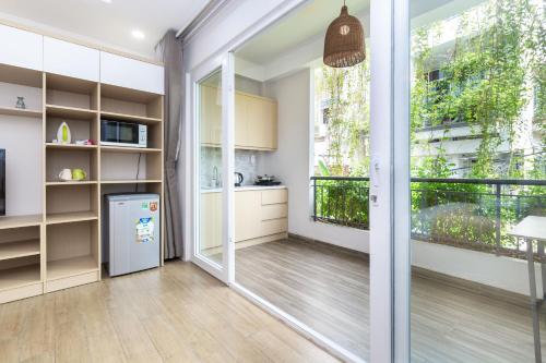 a kitchen with a refrigerator and a large window at Cozrum Homes - Yoga Corner in Ho Chi Minh City