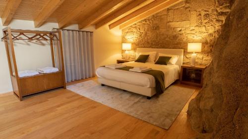 a bedroom with a bed and a stone wall at Casas da Penha in Penamacor