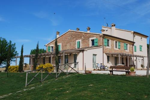 a large house with a bench in front of it at Le Maraclà Country House in Iesi