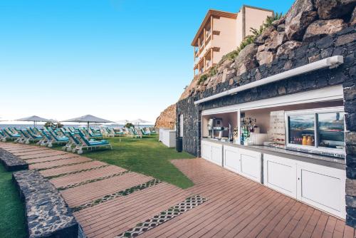 a patio with a bar on the side of a building at Iberostar Waves Playa Gaviotas All Inclusive in Morro del Jable