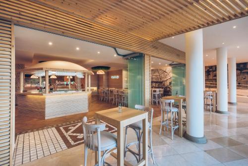 a restaurant with tables and chairs and a counter at Iberostar Waves Playa Gaviotas All Inclusive in Morro del Jable