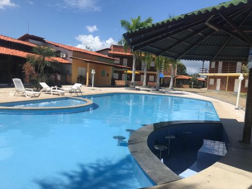 a large swimming pool with chairs and a patio at Chalé Temporada Porto dos Lençóis - Lençóis Maranhenses in Barreirinhas