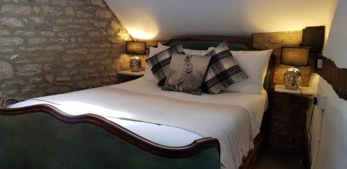 a bedroom with a bed with pillows on it at The Kings Arms Hotel in Stow on the Wold
