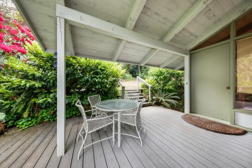 a patio with a table and chairs on a deck at Delake House in Otis