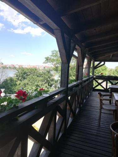 a wooden balcony with a view of the river at Pensjonat Stary Spichlerz in Ełk