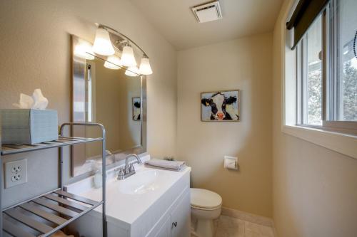 Un baño con lavabo, inodoro y espejo. en Apache Greens, en Sisters