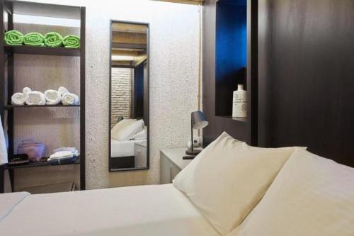 a bedroom with a white bed and a mirror at Athenian Residences in Athens