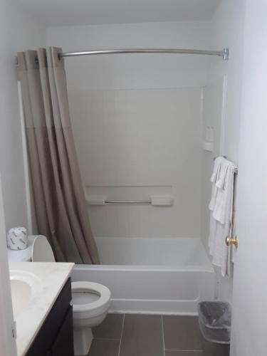Welcome Suites Hazelwood Extended Stay Hotel في هازلوود: حمام ابيض مع مرحاض ومغسلة