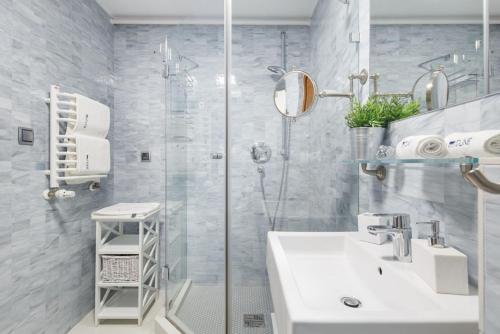 La salle de bains est pourvue d'une douche, d'un lavabo et d'une cabine de douche en verre. dans l'établissement Villa Dune, à Sarbinowo