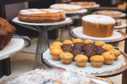 a display of different types of cakes and pastries on plates at Hotel Gabbiano in Mola di Bari