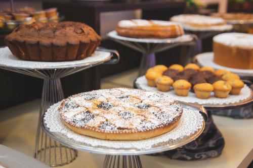 a display of different types of cakes and pastries on plates at Hotel Gabbiano in Mola di Bari