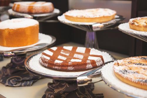 a bunch of cakes on plates on a table at Hotel Gabbiano in Mola di Bari