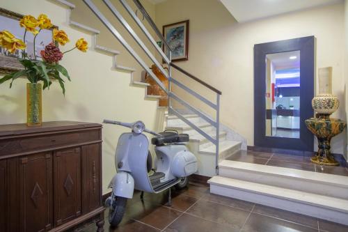 a scooter parked in a hallway with a staircase at Hotel Gabbiano in Mola di Bari