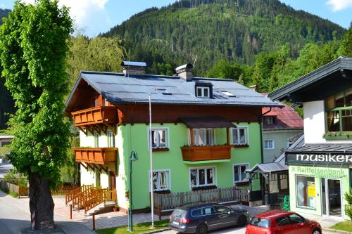 a green building with a black roof on a street at Apartment Holiday Lungötz in Annaberg im Lammertal
