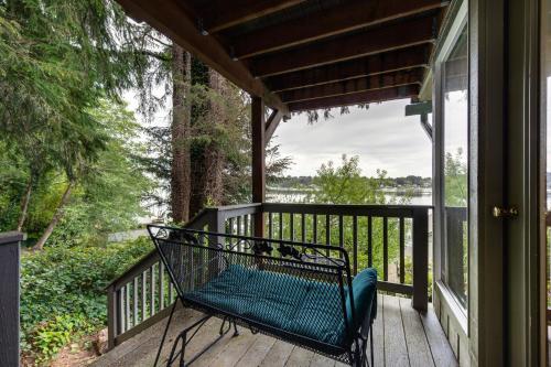 a bench sitting on the porch of a house at Delake House in Otis