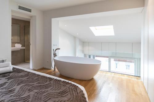 a large white bath tub in a bathroom at Bravissimo La Rambla penthouse in Girona