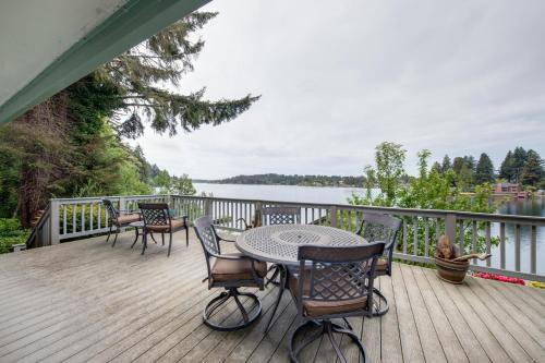 a table and chairs on a deck with a view of the water at Delake House in Otis