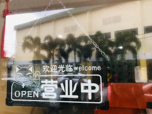 a sign hanging in a window of a store at Home Inn Hotel in Ipoh