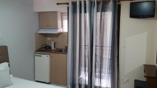 a kitchen with a sink and a window with curtains at Mavra Studios in Lygia