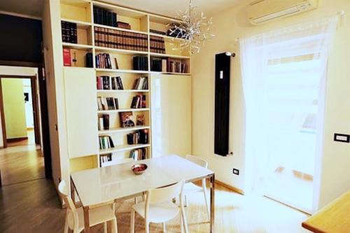 a white table and chairs in a room with a book shelf at Fairy Tales Ostia in Lido di Ostia