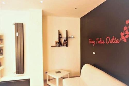 a living room with a white couch and a black wall at Fairy Tales Ostia in Lido di Ostia