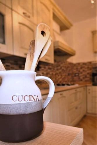 a white cup with a wooden spoon in a kitchen at Fairy Tales Ostia in Lido di Ostia
