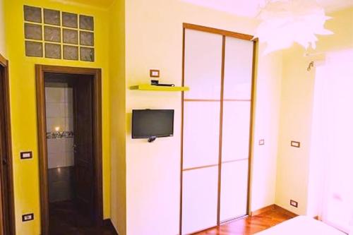 a room with a tv and a yellow wall at Fairy Tales Ostia in Lido di Ostia