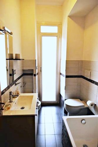 a bathroom with a tub and a toilet and a sink at Fairy Tales Ostia in Lido di Ostia