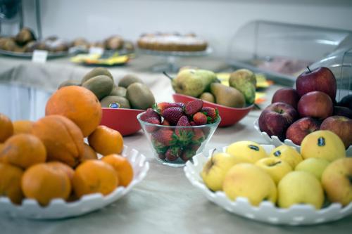 a table with bowls of fruit on top at Hotel Bruman Salerno in Salerno