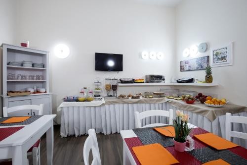 a dining room with a table and chairs and a tv at Hotel Bruman Salerno in Salerno