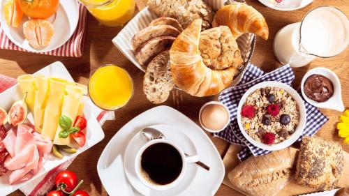 a table full of breakfast foods and coffee on plates at Hotel Gdańsk Boutique in Gdańsk