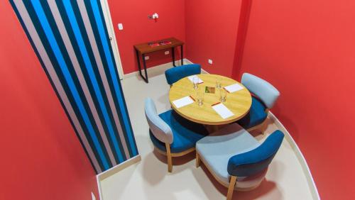 a dining room with a wooden table and blue chairs at Pop Art Hotel Las Colinas Manizales in Manizales