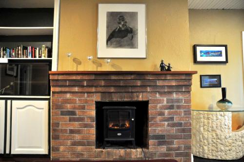 a brick fireplace in a kitchen with a fire place at Killilagh Accommodation in Doolin