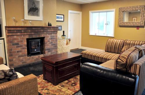 a living room with two couches and a fireplace at Killilagh Accommodation in Doolin