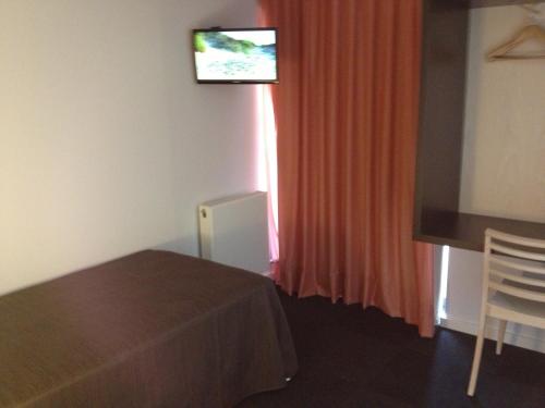 a hotel room with a television and a curtain at Apartaments i habitacions Can Morera Olot in Olot
