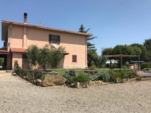 un giardino di fronte a una casa con piante di Agriturismo San francesco a Orbetello