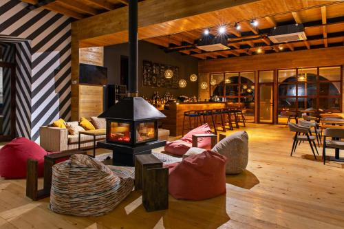 a living room with a fireplace and chairs and tables at Hotel Posta in Mestia