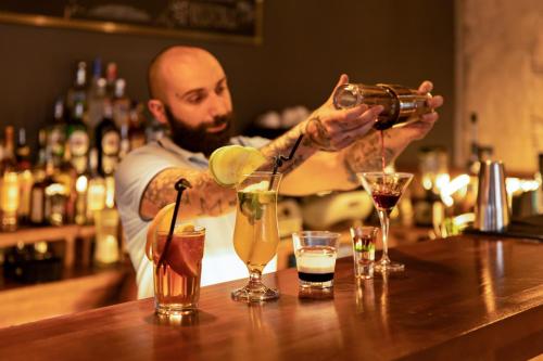 a man is making cocktails at a bar at Hotel Posta in Mestia