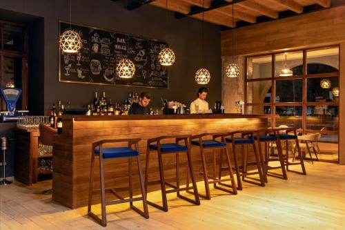 a bar with blue stools in a restaurant at Hotel Posta in Mestia