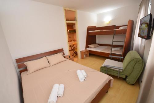 a bedroom with a bed and a bunk bed and a chair at Apartman Zoran in Herceg-Novi