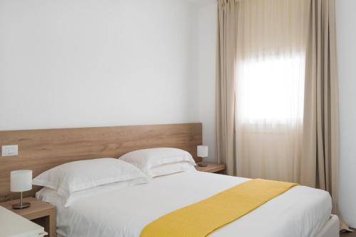 a bedroom with a large white bed and a window at Archinuè in Siracusa