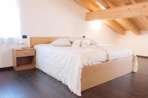 een slaapkamer met een bed met 2 kussens erop bij Hotel Milano in Tione di Trento